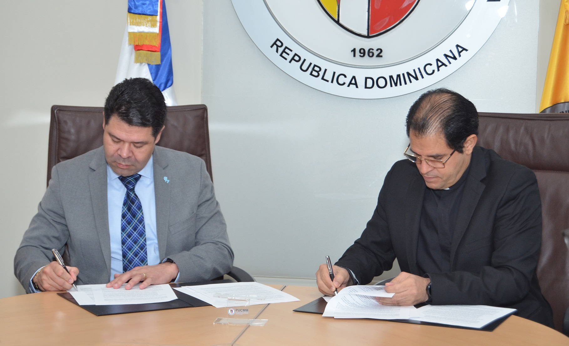 Los representantes de las instituciones firman el acuerdo.