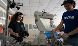 Estudiante manipulando brazo robótico Mitsubishi, reflejando la formación técnica de alta demanda en el mercado laboral dominicano.